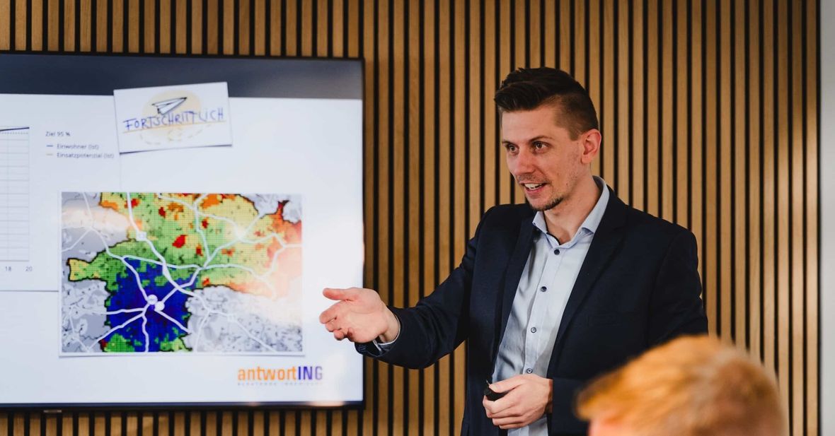 Referent zeigt auf eine farbige Gebietskarte auf einem Bildschirm